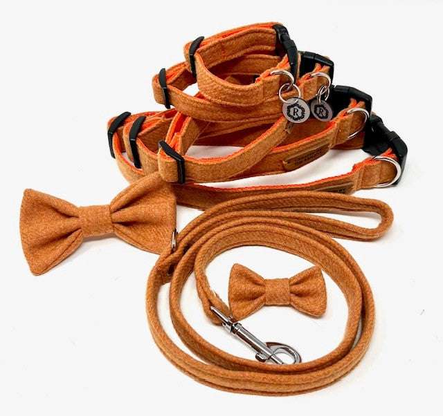 A set of British tweed dog collar, lead, and bow tie in orange, displayed on a white background.