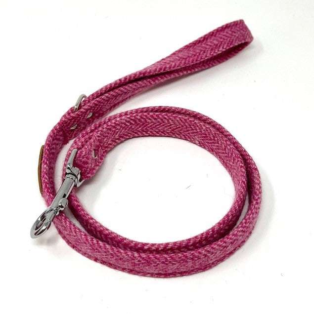 Pink dog leash with a silver clasp on a white background