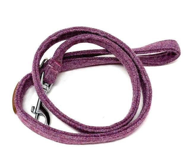 Purple dog leash with a metal clip on a white background